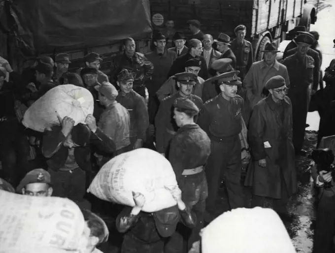 Gen. Robertson Inspects Food Base For Berlin -- General Sir Brain Robertson, British Military Governor in Germany, centre of three officers, watches German workers carry sacks of flour to awaiting aircraft at Wunstorf Airport, near Hanover, Germany, base for supplying food by air to Berlin. Day and night a constant stream of aircraft leave Wunstorf for Gatow, Berlin, taking in supplies of food for the two million German in the Western sectors of the German Capital in the face of the closing by Russia of land routes into the city. July 4, 1948. (Photo by Associated Press Photo).