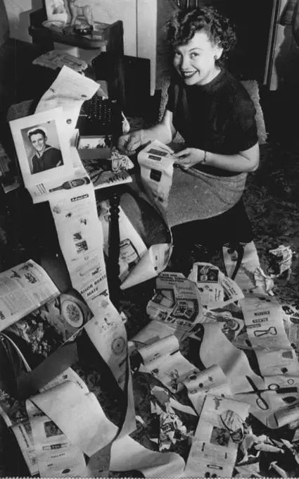 "Postoffice" by Long Distance. Betty Adams (above), 18, thinks she has an answer to her fiance's complaints that her letters are too short: An epistle 36 feet long and weighing five pounds. She finished it today and it's going off to Donald W. Jackson, 21, of Denver, a fireman aboard the U.S.S. Wisconsin at Portsmouth, Va. Betty typed the letter on shelf-lining paper and pasted on it photos, clippings, razor blades, sticks of gum and other knick-nacks. March 20, 1951. (Photo by AP Wirephoto).