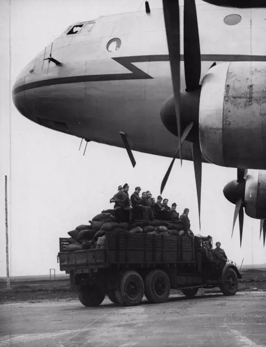 Fuel For Berlin By The Airlift Coalmen -- A lorry loaded with sacks of coal passes under the nose of the "aerial coalman", a giant Ha stings aircraft, at Schleswigland. The first of the new giant air freighters, the Royal Air Force Handley Page Hastings, are now being used on the air lift to Berlin, Germany. They are operating from the ex-Luftwaffe night-fighter station at Schleswigland where 19,000 tons of soil has been remove and 7,000 tons of concrete laid in the last 15 days to get the aerodrome ready for the giant aircraft that can make the trip to Berlin in one hour and carry a load of nearly 7½ tons. November 03, 1948. (Photo by Reuterphoto).