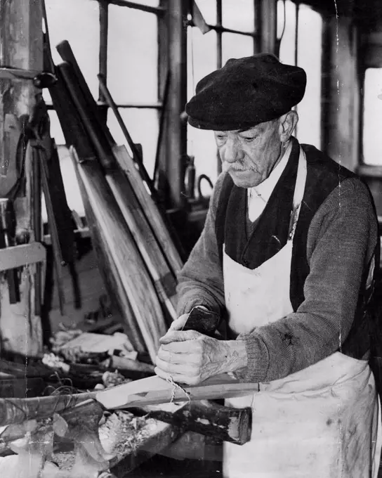 Famous Bat - Maker's Shed To Be Demolished Outside The Oval - ***** Killick at work in his shed at the back of his house in Clayton-street, shortly to be demolished. The old shed just outside the Oval a resort of famous cricketers for sixty years or more, is to be demolish shortly to make room for a block of new L.C.C. flats. The shed is owned by Albert Killick the last surviving member of a famous firm of batmakers. Who is collecting up his tools, preparing to move to new business premises. April 9, 1934. (Photo by The Associated Press).