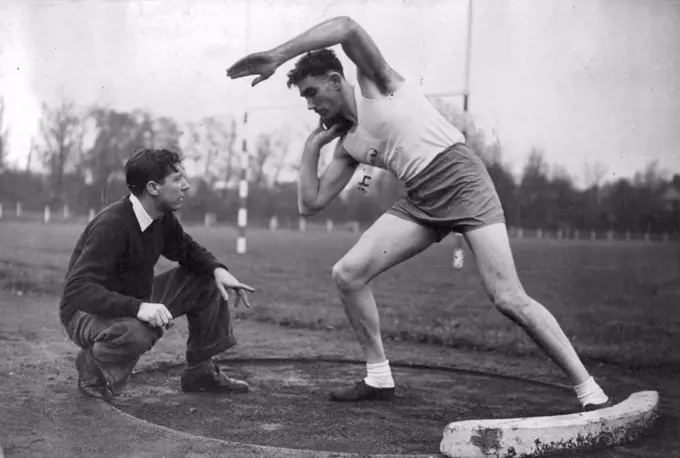 Britain's Possibles For The Next Olympic Games - John Savidge, now serving with the Royal Marines, and who specialises in the Shot and Discus, gets a few hints from Geoffrey Dyson during training at Motspur Park, London. November 11, 1949. (Photo by Sport & General Press Agency, Limited).