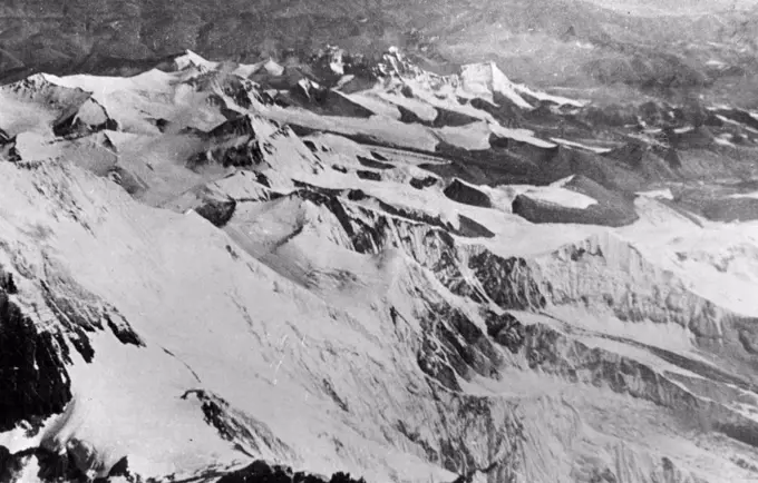 Everest. A new view of the South Col of Everest, looking north. In the extreme foreground, slightly right of centre, is Lhotse, while at the base of - the large white snow patch in the bottom left corner is the South Col. Below, and to the left of it, are the slopes leading down to the Western Cwm. Behind the snow patch is the snow-covered east face of Mt. Everest. Tibet lies in the background. March 12, 1953.