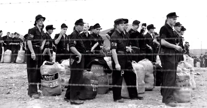 German Prisoners of War wait for start Home : German Prisoners of war make their last stand behind barbed wire in the United States as they wait at Camp Shanks, Orangeburg, N.Y., July 22, for the start of their Journey Home. This is the final group, consisting of 1,385. German Prisoners of War, to leave the U.S. leaving fewer than 300 prisoners scattered throughout the country in hospitals and special detention camps who will be returned individually. July 22, 1946. (Photo by Associated Press Photo).