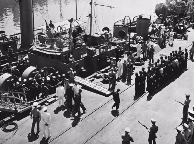 U.S. Coast Guard Cutter Sinks German U-Boat, Captures 33 Of Crew -- As U.S. Marines with fixed, bayonets stand guard, 33 officers and men of a German submarine are taken off the U.S. Coast Guard cutter Icarus, which sank their raider off the American East Coast. The cutter encountered the U-boat while on Atlantic patrol, damaged the German vessel with depth charges and finished her off with ***** when she came to the surface. The 33 survivers, including the submarine's commander, were picked up and brought to U.S. Navy base where they are shown being lined up to be marched to their guard. July 12, 1943. (Photo by U.S. Office of War Information).