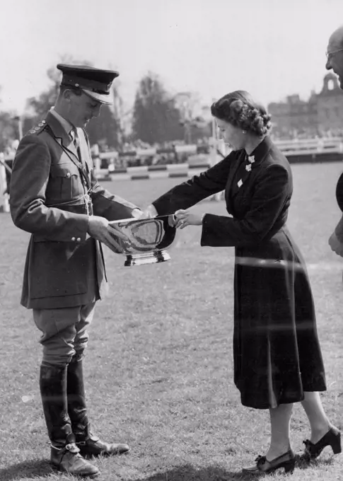 The Queen Presents The Trophy To Guard Winner At Badminton -- HM the Queen photographed yesterday, Friday, presenting the trophy to Captain H.A.Q. Darley, of the Royal Horse Guards, winner of the three-day equestrian test at Badminton. The Queen, the Duke of Edinburgh and Princess Margaret, at present staying at Badminton House, Glos., as guests of the Duke of Beaufort, have been spectators at the British Horse Society's Olympic Trials held i the grounds of their host's estate for the past three days. April 26, 1952. (Photo by Fox Photos).