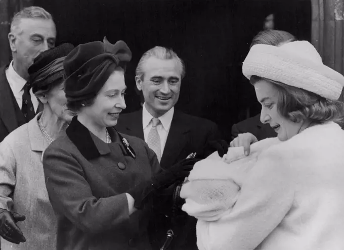 The Queen Stops The Baby Crying - The Queen looks down her godchild, Edwina, in the arms of her other, Lady Pamela Hicks. April 16, 1962. 