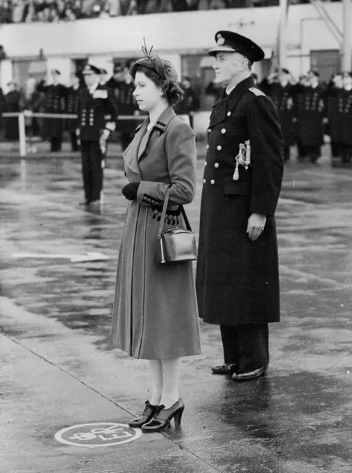 The Queen Takes The Salute: The Queen, standing on a specially-marked spot bearing the Royal Oypher, takes the salute at Lee-on-Solant today (Friday). Behind her is the flag officer air (Home), Vice-Admiral C.E. Lamre. Paying her first visit to a naval establishment since her Accession , The Queen today (Friday) visited The Royal Navy's Home Air Command at Lee-on-Solent, Hampshire. She travelled from London by rail to Fort *****, completing her journey by car, which was escorted by two S.51 Weatland Sikeraky Dragonfly helicopters - the type that has been operating on rescue work behind enemy lines in Korea. November 21, 1952. (Photo by Reuterphoto) 