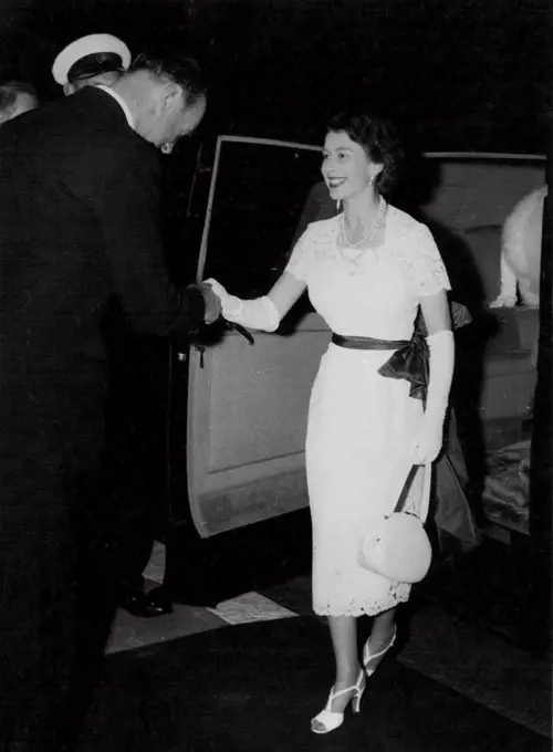 Looking delightfully summery ion this white lace dress, the Queen is welcomed to the International Horse Show at London a White City last night. The greeting handshake comes from Lord Beaufort, president of the show. The Queen, who was accompanied by the Queen Mother Margaret, went to watch the jumping in the final for the King George V Gold Challenge Cup. The Luke of Edinburgh was Joining them later. He flew back to Buckingham Palace by helicopter from Cambridge, and arrived at the Palace only a Quarter of an hour before the Queen left for the show. July 21, 1955. (Photo by Daily Mirror).