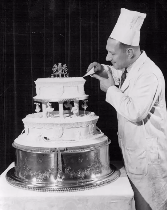 Prefabcriake For Tomorrow's Royal Christening Mr. Harry Wargg, Cake decorator to E.C.Bell of Sheffield, putting the finishing touches to the icing. He came to London specially for the job, at Goring Hotel, Grosvenor Gardens. Princess Elizabeth and the Duke of Edinburgh have accepted the gift of a double-tiered 35lb cake for tomorrow's christening of the baby Prince. It has been presented by the Universal Cookery and head Association and members from all parts have contributed ingredients. The cake has been assembled in London, the tiers being "prefabricated" by students at the City of Manchester Training College of Domestic Economy and by the Club of the three Wise Monkeys, the finishing school in Pont Street, London. December 14, 1948. (Photo by Reuterphoto).