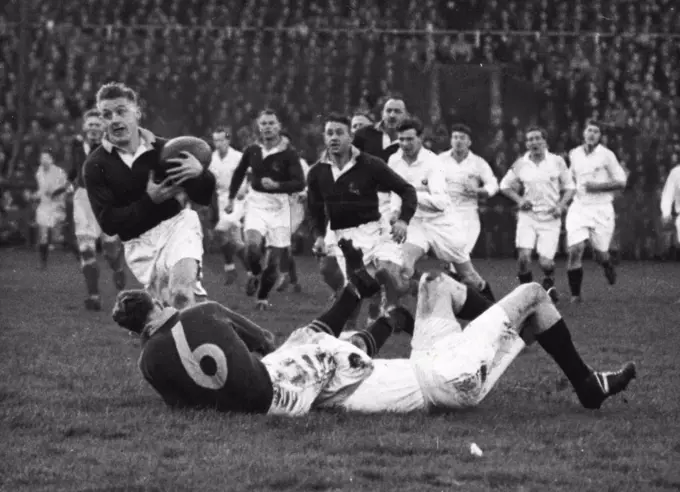 Crushing Defeat Of Scotland -- P.A. Du Toit (S.A.) gets away with the ball after P. Johnstone (S.A.) had been tackled by a Scottish Three Quarter. South Africa won a resounding victory when they defeated Scotland at Murrayfield by 44 points to nil in the first of the rugby international matches. November 25, 1951.