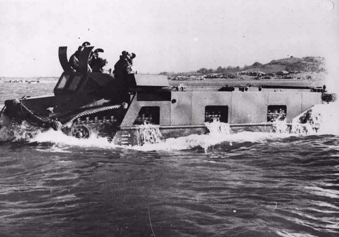 The Neptune Amphibious Tank -- "Neptune" putting out to sea. This British tracked amphibious vehicle is a ship-to-shore load carrier capable of self-propulsion in any sea, able to land on a beach through heavy surf, and to move across country. "Neptune" can take a pay load of approx; four tons and has a large unobstructed hold, which makes it particularly suited for the carriage of a wide variety of equipment, including the 17-pounder anti-tank and 25 pounder filed guns, vehicles, casulaties, and stores. "Neptune" is equipped with navigation lights in addition to normal road lamps, a wireless  set operated by the driver's mate. October 27, 1945. (Photo by Central Press Photos Ltd.).