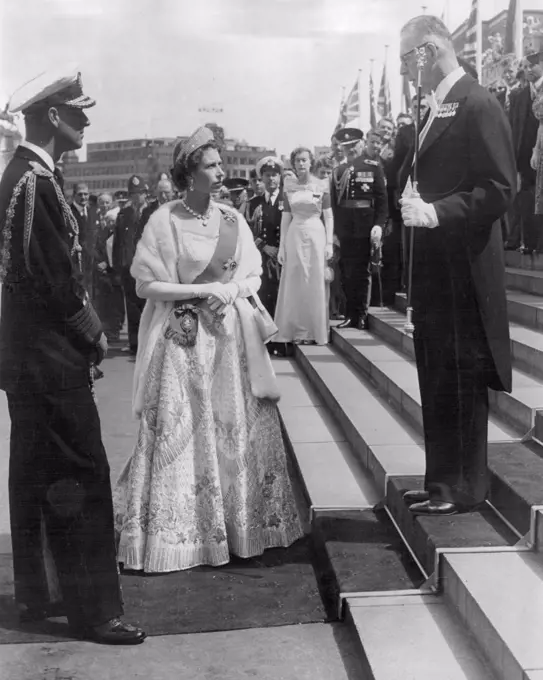 Historic scene, shows Queen Elizabeth and Duke of Edinburgh being welcomed at Parliament House, Wellington, New Zealand, when they arrived for the Opening of Parliament. Usher of the Block Rod, Major D. Brown welcomed the Royal couple. The Queen wore her magnificent Coronation gown. February 03, 1954.