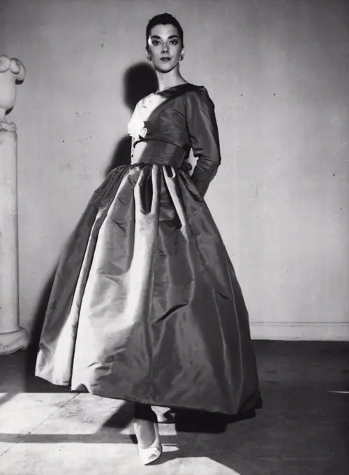 Scarlet Nights -- A red faille evening gown with a close-fitting bodice covered by a bolero, and with a barrel-shaped full skirt - form the autumn collection of the Spanish couturier Balenciaga, of Paris. August 31, 1955. (Photo by Associated Press Photo).