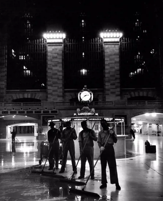 While The Big City Sleeps (Fourth Of Ten) -- A lone traveller (right) watches as Grand Central Station gets its nightly mop-up. Sixty-four porters use 4000 gallons of water to clean a total of 80,000 square feet per night. April 22, 1949. (Photo by Acme).