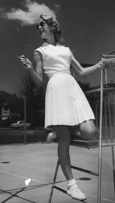 The double-breasted sleeveless dress in white pique has a skirt that's a flurry of knife pleats. December 05, 1955. (Photo by Jack Hickson, Australian Photographic Agency).