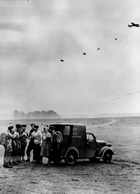 They've Come Down to Tea - Coming down for tea - parachutists making their descent find the Y.M.C.A. tea car ready for them with a cup of tea. One of the most unusual Y.M.C.A. centres Britain to-day is a small hut standing in the middle of a parachute training school where the instructions of future paratroops make their own initial jumps. The women workers at the Centre often work from 6 a.m. until midnight, so great is the demand for cakes and tea. June 03, 1942. (Photo by Fox Photos)