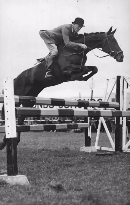 British Olympic Horsemen Show Their pages : Major Borwick on "The Abbott" takes a jump in fine style during the Dressage Test.The British Equestrian team for the forthcoming Olympic Games gave a demonstration of their skill at the Three Counties Agricultural show at Gloucester. June 09, 1948. (Photo by Sport & General Press Agency, Limited).