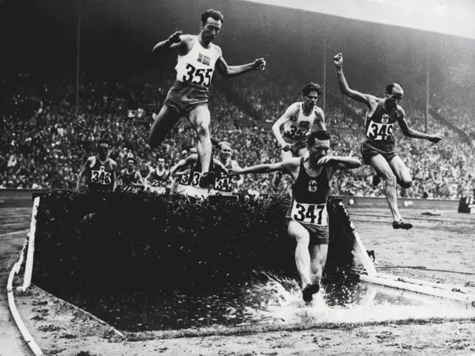 XIV Olympiad - Swedes Sweep Board In 3,000 Metres Steeplechase : 3,000 Metre Steeplechase competitors taking water jump at Wembley Aug 5. seen in picture are E. Elmsaeter of Sweden (355); M. Chesneau of France (347);  R. Pujazon of France (349) T. Sjoestrand of Sweden (357); P.V. Siltaloppi of Finland (345) and A. Cuyodo of France (348).The Olympic 3,000 metres steeplechase at Wembley Aug. 5 was won by Thure Sjoestrand of Sweden in 9 min 4.6 secs; with E. Elmsaeter of Sweden second and G. Hagstroem, also of Sweden, third. August 20, 1948. (Photo by The Associated Press Ltd.)