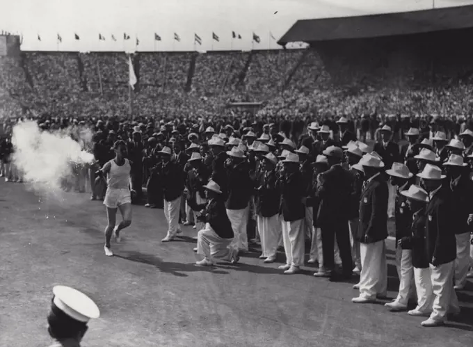 The Olympic Games, Wembley, London, 1948 : Members of the American men's team enthusiastically clap the final torch-bearer as he makes his round of the Stadium. July 29, 1948. (Photo by Fox).