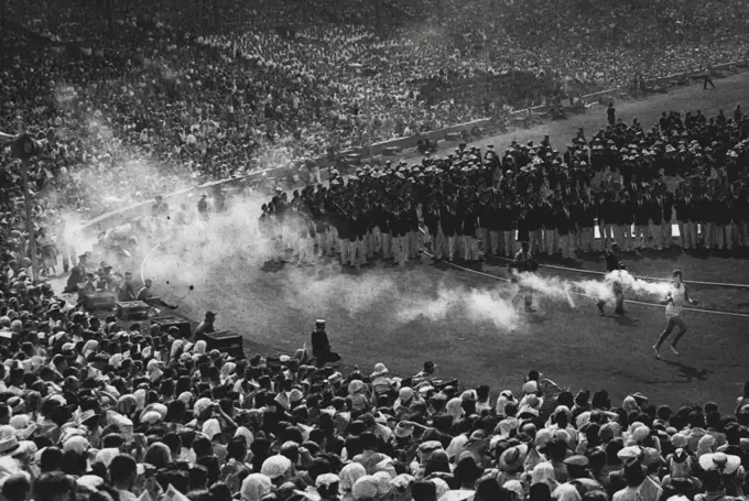 The Flame Reaches The End of Its Journey: John Mark, the mystery torch - bearer, carrying the Olympic Flame round the arena at Wembley on the last stage of its 200 - mile journey from Greece, before he lights the bowl where the flame will burn till the end of the Games. John Mark was selected as the personification of the athletic youth of the country. July 29, 1948.