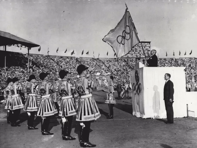 Closing Of The Games Of The XIV Olympiad : Standing on the Tribune of Honour (nearest camera) Sir Frederick wells, Lord Mayor of London, holds the Olympic Flag which will remain in his safe keeping till the XV Olympiad which is to be celebrated in Helsinki. Also seen in this picture, made during the closing of the Games of the XIV Olympiad at Wembley Stadium, London, August 14th, are J. Sigfrid Edstrom, President of the International Olympic Committee (on Tribune furthest from camera) and standing right foreground is Lord Burghley, Chairman of the organising Committee. On left are State Trumpeters. August 14, 1948. (Photo by Reuterphoto).