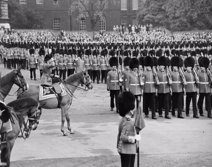 Queen taking the salute at the Trooping the Colour ceremony on horse Guards parade. The Queen rode from Buchingham palace today to take the salute at the trooping the Colour ceremony on Horse Guards parade. Record crowds lined the route to watch the Queen go by, and from the early hours of this morning people had waited on Horse Guard's parade to see the ceremony. The Queen rode side-saddle on the police horse Winston and wore her specially designed Guard's uniform - a scarlet tunic, dark blue riding skirt, and a tricorne hat with the gold badge and white plume of the Grenadiers. Behind the Queen rode Prince Philip, in fieldmarshal's uniform, and the Duke of Gloucester, Colonel of the Scots Guards. On horse guards parade, the Colour of the 1st Battalion the Grenadier Guards, the senior Guards regiment, was trooped. After the ceremony the Queen rode back along the Mall where she took a final salute at the gates of Buckingham palace. June 11, 1953. (Photo by Daily Mirror).