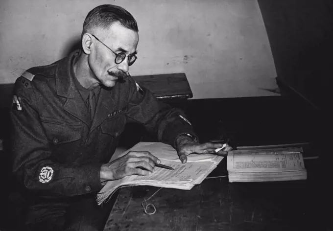 Would Not Wash With Corporals -- Staff quartermaster Sergeant Adams studying his file of documents during an interval in his court martial. Staff quartermaster sergeant Henry Adams of the Royal Army ***** corps was ordered to move from one mess to another. This would have involved him washing with corporals and so he refused. Yesterday he faced a court martial at Bicester, Oxfordshire, on a charge of disobeying the order of his commanding officer. S.Q.M.S. Adams conducting his own defence and endeavoured to prove with the aid of one hundred documents that the order was unlawful. November 7, 1951. (Photo by Paul Popper).