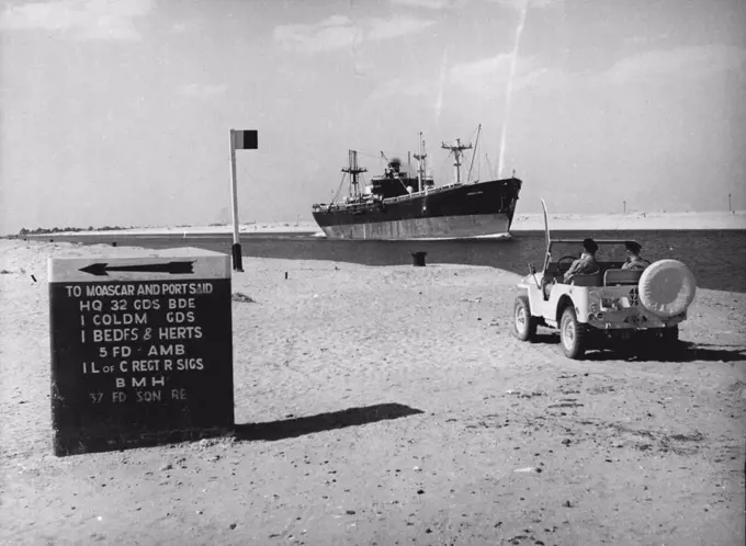 Egyptian Sabres Rattle -- A freighter passed through the Canal watches by British soldiers. The sign-post direct to British army units in the area. January 15, 1954. (Photo by Paul Popper Ltd.).