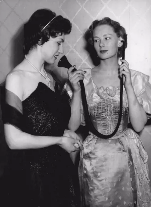 Fashionable Hearing - The old You Know - the New You Cannot See. Hazel Innes, on the right shows an Edwardian type of hearing aid to Gillian Davis, who is in fact wearing a modern hearing aid which is incorporated in the Pearl Necklace she is wearing, the main "Michrophone" part being in the Cluster of Pearls in the front of the Necklace.A Unique Fashion show was held in London today, ***** the latest trends in ***** Hearing Aids.Among those ***** were models ***** ties, Scarved and ***** for men and in ear-rings, ***** scarf clasps, Hair-bands and Necklaces for women. May 10, 1955. (Photo by Paul Popper, Paul Popper Ltd.). 