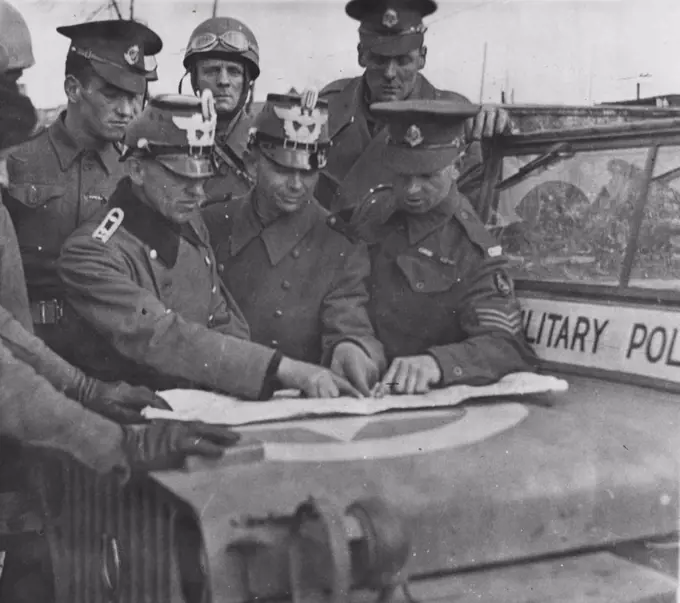 British Troops Enter Hamburg -- British military policeman giving ***** to German policemen in Hamburg. June 25, 1945. (Photo by British Official Photograph)