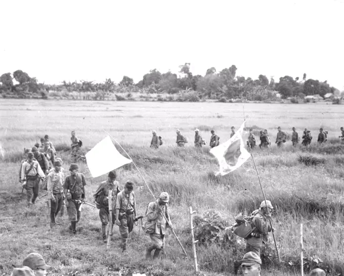 Japs Surrender At Bataan - A serpentine column of surrendering Japanese soldiers cross a green rice paddy as they approach waiting 38th Div. troops. Fifty officers and 400 men, all that remained of more than 6,000 enemy troops, surrendered at Orion and Bagac, Bataan. They are shown moving along the same trail over which Americans made the infamous "death march" in 1942. This enemy force, under Col. Nagayoshi was completely defeated in battle by veteran 38th Div. troops in their reconquest of historic Bataan peninsuls. April 9, 1945. (Photo by U.S. Army Photo).