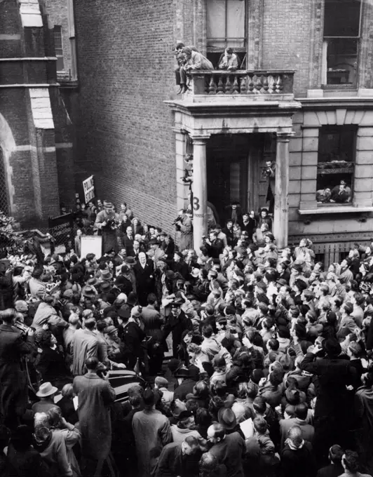 Churchill Leaves Polling Station - Cheered by Huge Crowds.Huge Crowds Churchill, cheering him as he leaves the polling station after casting his vote in the General Election today (Thursday). He an be seen between the two doorways.Mr. Churchill voted in St. Stephen's Church Hall, Emperor's Gate, Gloucester Road, London. October 25, 1951. (Photo by Reuterphoto).