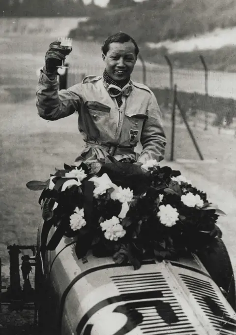 Siamese Prince Wins International Trophy Rage at Brooklands - Prince Birobonge after his great victory at Brooklands this afternoon.Prince Birabongse, of Siam driving an E.R.A. under the name of  "B.Bira" won the 250 miles International Tropy Race, organised by the Junior Car Club, at Brooklands, the famous Surrey race track, this afternoon. Reymond Mays, also driving an E.R.A. gained place. There were a member of women competitors in the race. May 02, 1936. (Photo by Topical Press).