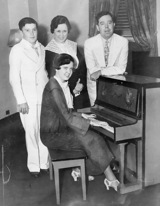 Then the Longs Visited New York -- New York-here's the family of Senator Huey P. Long of Louisiana, photographed when they visited here July 25, and the senator took time out to show the town how to make a Gin Fizz. At the Piano is daughter Rose; in back, left to right, Palmer Long, Mrs. Long and the "Kingfish," who was shot and seriously wounded in the Baton Rouge, La., state house September 8. September 9, 1935. (Photo by Associated Press Photo).