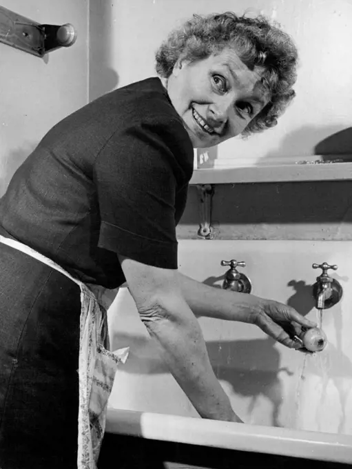 Mrs. Henry Cabot Lodge wears dress with flower-seed package designs as she cuts green peppers. September 22, 1947.