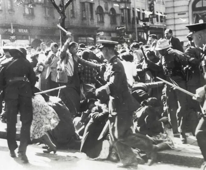 Police Charge Meeting -- Women fall to ground as baton-wielding police charge a protest meeting in front of the city hall in Johannesburg, South Africa. Melee ensued after police arrested E. S. Sachs, veteran labor organizer, who was addressing a meeting called to demonstrate against a Ministry of Justice order to Sachs to quit his post as general secretary of the Garment Workers Union. Although melee took place May 24, these pictures have just become available in the United States by mail from South Africa. June 26, 1952. (Photo by AP Wirephoto).