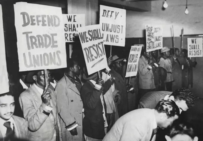 Passive Resistance Marchers In Johannesburg -- "Volunteers," with their banners proclaiming resistance to racial discrimination laws and anti-trade union action; assemble in Anderson Street, Johannesburg, for a curfew-breaking march on the City Hall.The march was part of the passive resistance campaign conducted by non-Europeans against racial segregation in the Union.More than 2,000 people have already been arrested, according to one campaign leader. September 29, 1952. (Photo by Reuterphoto).