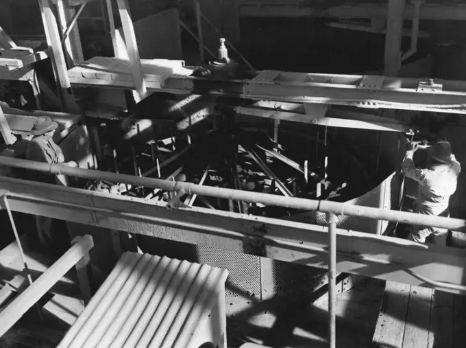 A giant rotating washing machine at the De Beers Diamond mines, Kimberley. Thousands of tons of gravel and water are fed into this machine daily, and once the scum, dirt and sludge are washed away the clean gravel is tapped, and allowed to run onto a table which has been specially constructed to retain diamonds. October 10, 1952.