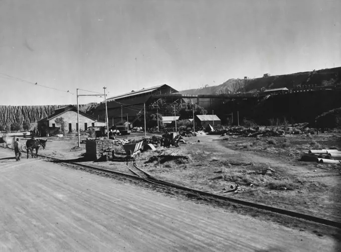 A view of a section of the De Beers diamond mines at Kimberley, S. Africa. In the background are low hills of exhausted "Blue Gravel" taken from the Big Hole, the Du Toitspan workings and other mines. This "Blue Gravel" yielded some of the purest diamonds found in any part of the world. October 10, 1952.