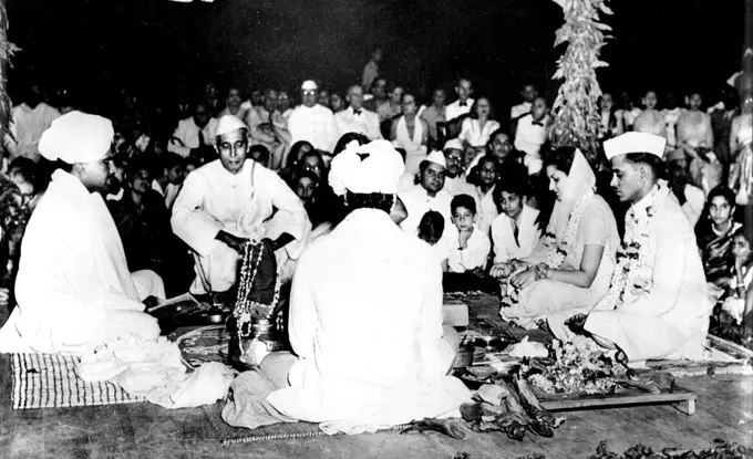 Nehru's Niece Married -- The Bride and Bridegroom (right), Garlanded with flowers and Jewels, make their pledge before Agni (fire) during their marriage ceremony.Chandralekha Pandit, daughter of Mrs. Vijaya Lakshmi Pandit, and Niece of Prime Minister of India Pandit Nehru, was married to Mr. Ashok Mehta, Indian Consul-General in Saigon, at New Delhi, India, April 14. The marriage ceremony was attended by the Governor General of India, members of the Cabinet, The Diplomatic Corps, and other distinguished personalities. May 01, 1949. (Photo by Associated Press Photo)