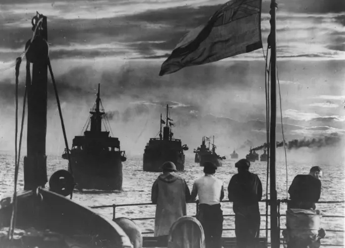 Food Convoy! -- A striking picture taken from one of 24 vessels which were under convoy along the East Coast of Britain, as the sun was setting on the food fleet, with look-out men and a naval gunner keeping watch. Other ships, some camouflaged, sailed astern. September 14, 1940. (Photo by Keystone).