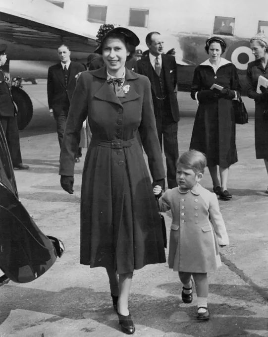 Prince Charles Welcome Home For Mother :Prince Charles holding the hand of his mother Princess Elizabeth, as they walks to the Royal car at London Airport to-day (Tuesday) when the Princess returned home after her visit to home with the Duke of Edinburgh.The Prince was there when the Viking aircraft of the King's Flight landed, and he entered the aircraft to greet his mother. April 24, 1951. (Photo by Reuterphoto).