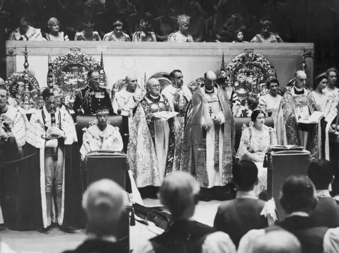 The King And Queen During The Coronation Service -- King George (sitting, on left) and Queen Elizabeth (sitting of right) during the coronation service in Westminster Abbey. The Royal Ladies in the Royal Box above are (left to right, star ONG second from left) Duchess of Kent, Duchess of Gloucester, Queen Maude of Norway, Queen Mary, Princess Elizabeth, Princess Margaret Rose.Amid Glittering Scenes of Traditional splendour the king and Queen rode to Westminster Abbey from Buckingham palace to be crowned. A Buge, colourful Procession accompanied the State coach. February 9, 1952. (Photo by Associated Press Photo).
