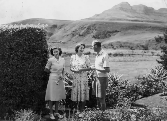 The King And His Daughters On Holiday In Natal -- Princess Elizabeth smiles at the King in the *****  spaces of the Natal national Park. On left, ***** a flower, is Princess Margaret.The Crowded South African tour of the British Royal family was interrupted for four days while King George, Queen Elizabeth and their daughters, Princess Elizabeth and Margaret took a well-earned rest in the Natal national park, situated on the Natal-Basutoland border 60 miles south-west of Ladysmith. The Royal Party stayed in a thatchod hostel at the foot of the Drakensburg Mountains, from where they were able to take walks in the Drakensburg foothills.The Princess were also able to do some swimming. March 22, 1947.