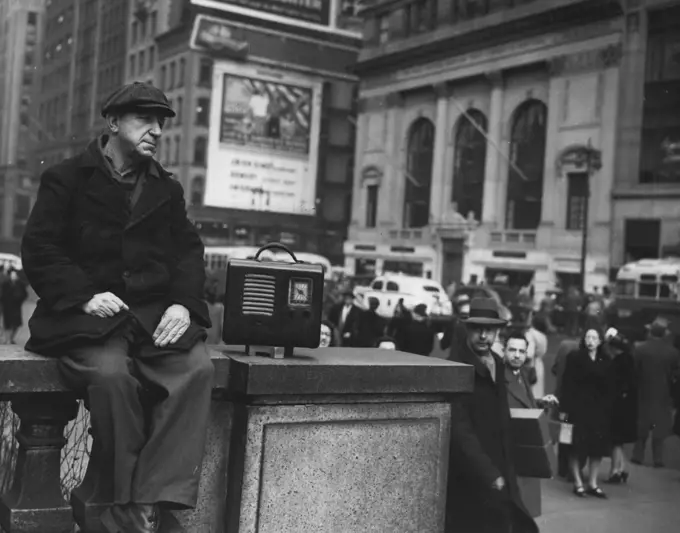 Fifth Avenue Interlude -- Fifth Avenue, the street of fashion and swank in this city, was a street with music today as Otto Feinberg, a longshoreman, paused to listen to this radio as he sat on the terrace wall in front of the New York Public Library on the corner of 42nd Street. Otto, while waiting for the time of his night assignment to roll around, sat in the sun, amusing himself and passers-by.No one thinks it strange that wharfie Otto Feinberg sits on a wall in Fifth Ave., street of swank and fashion to listen to his radio. January 29, 1947. (Photo by Wide World Photo).