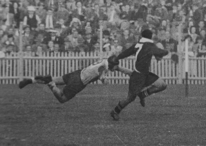 Powerful leg drive directs tackler's body to hit back of opponent's knees. Arms are outspread to trap his legs, pitch him to the ground. April 05, 1950.
