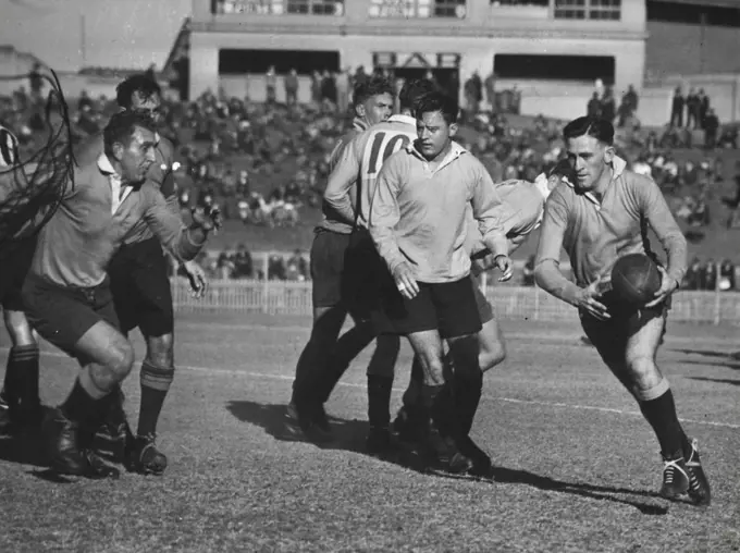 Roy Cawley the Rest's half back (right) dashes fast Queensland forward Kew Hodda (centre) as Keith Window comes arrow at cut him off the rest won 30-22. August 12, 1946.