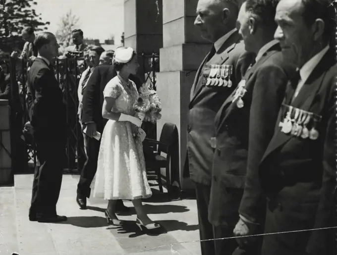 The Queen has a warm glance for three VC holders, standing in their places of honor, as she entered the Anzac Memorial this morning. Pictured are A.C. Hall, Judge Storkey, and Joseph Maxwell. February 5, 1954.