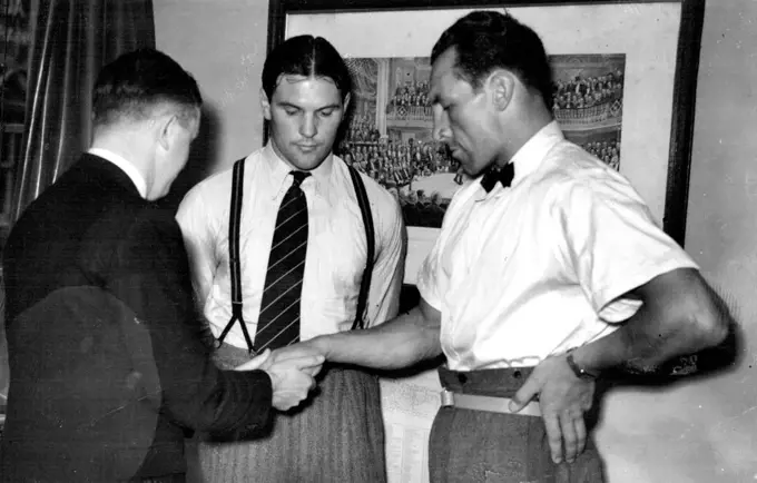 Medical Test for Phillips And Foord -- The doctor examining Phillip's hands, watched by Ben Foord.Eddie Phillips and Ben Foord, who meet at harring on Tuesday ***** postponed fight,  were tested by a doctor at Syd Hull's office in Shaftesbury Avenue today. June 18, 1938.