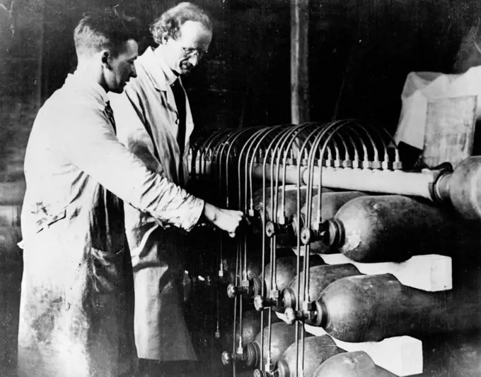 10 Miles Up In A Balloon -- Prof. Piccard testing the gas containers with which the balloon is filled. In a hermetically sealed cylinder hanging from a giant balloon, a Swiss scientist today began an attempt to go higher in the air than man has ever gone before. He is Prof. Auguste Piccard, member of the staff of Brussels University, and he hopes to reach a height of ten miles above the earth. He is accompanied by an assistant. The start was made soon after dawn from a field at Augsburg, Bavaria. May 27, 1931. (Photo by Topical Press).